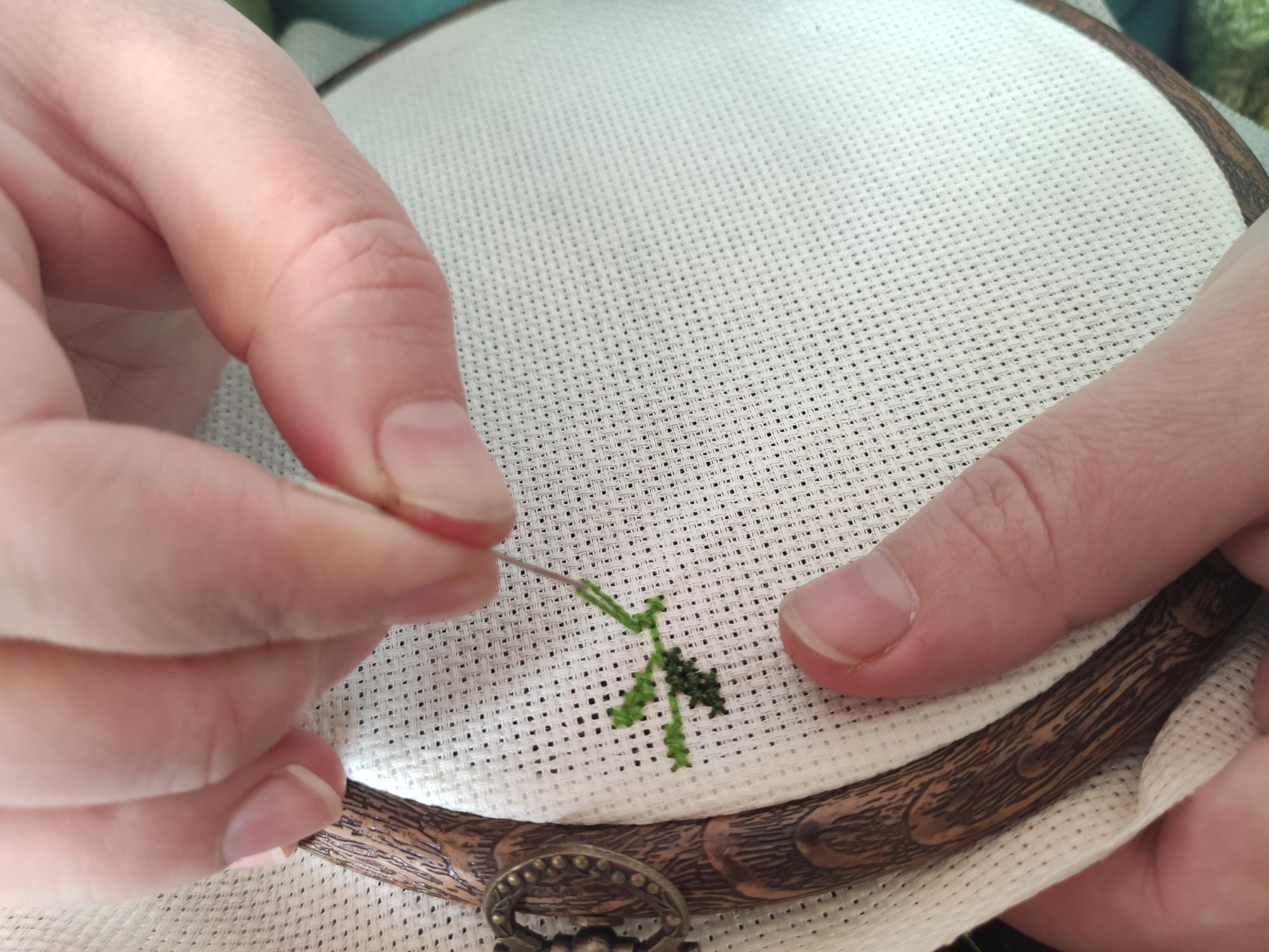 Close-up of hand embroidery on linen with warm tones
